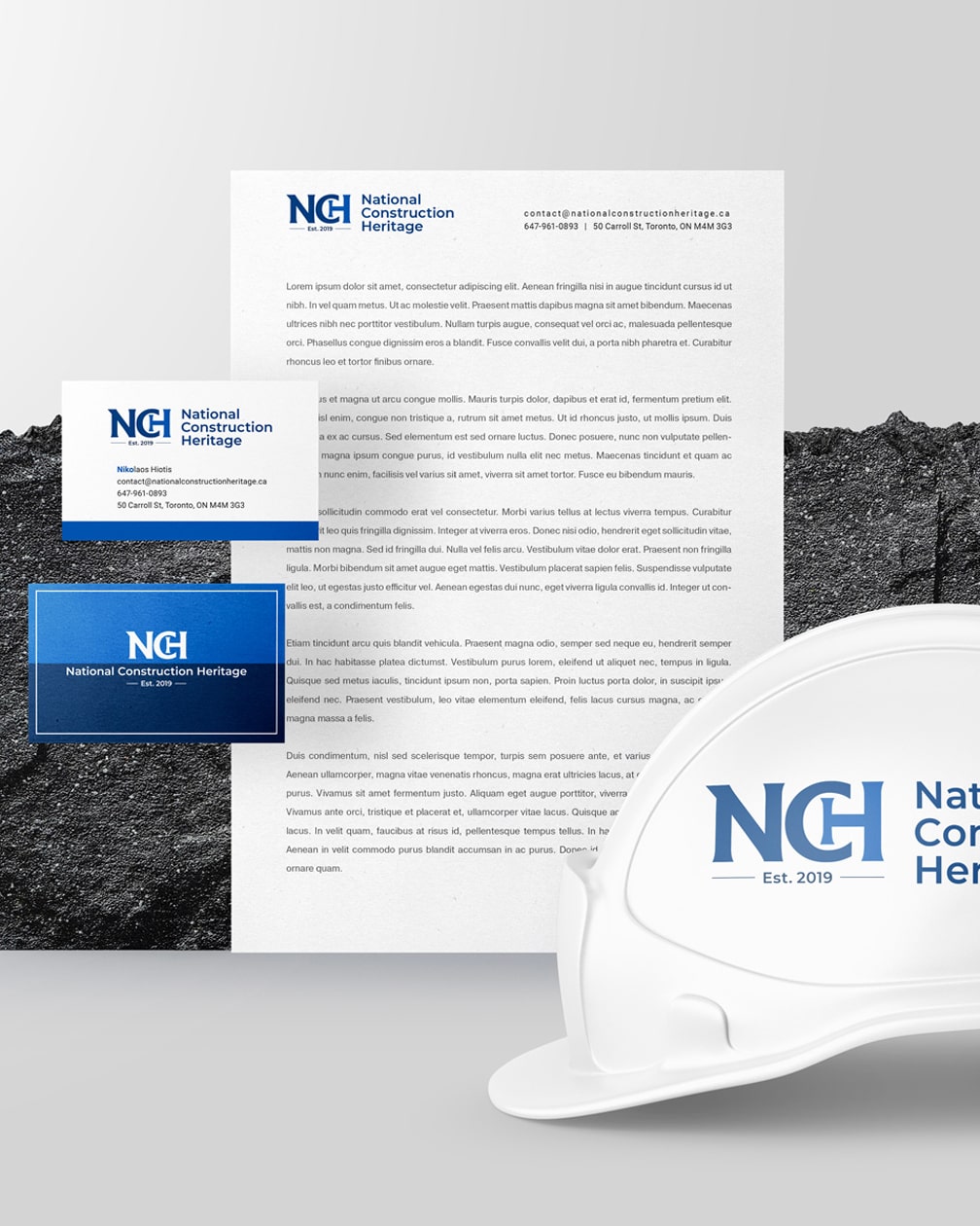 Professional branding materials for National Construction Heritage, featuring a clean logo design on a white hard hat, letterhead, and business cards, exemplifying a polished logo design for building contractors established in 2019.