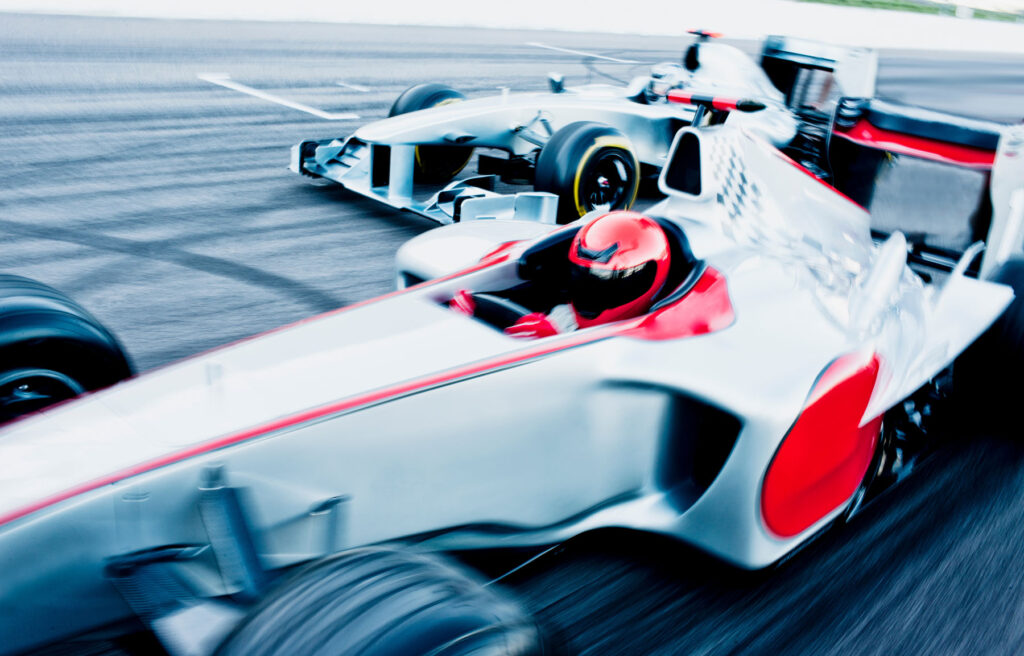 High-speed motion blur of a Formula One car racing on the track, symbolizing the agility and efficiency required in website maintenance, for the article section 'Benefits of Regular Website Maintenance' in 'Essential Monthly Website Maintenance Services for Small Businesses'.